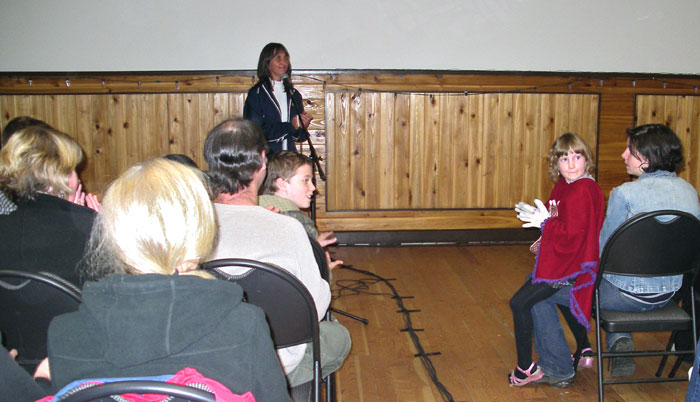 Woman talking into the microphone and giving a presentation in the hall