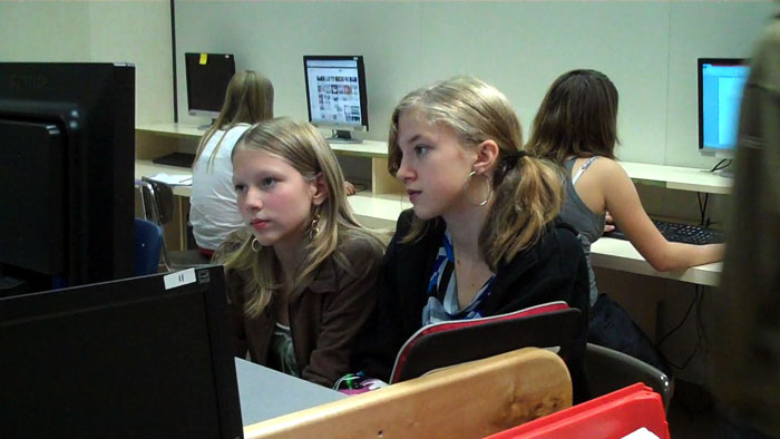 Two girls looking into a computer