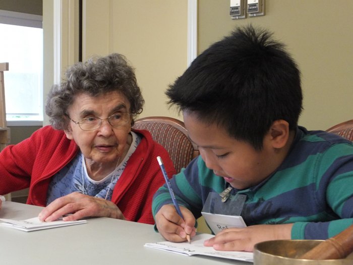 Young boy and elderly woman working together