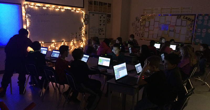 Students working on their laptops in a classroom.
